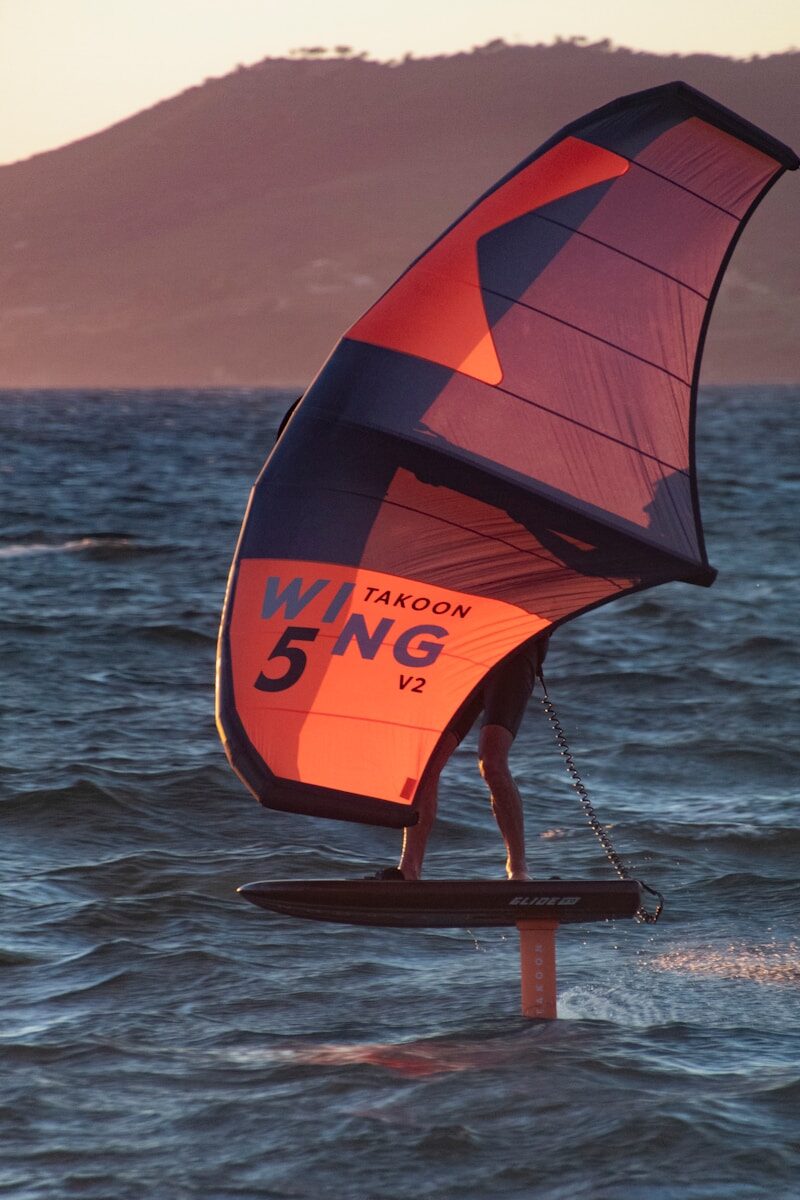 a person holding a large orange and red object in the water